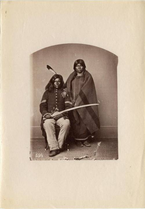 Why does the Pawnee warrior Loots-Tow-Oots hold a sword in the photograph taken of him and his wife