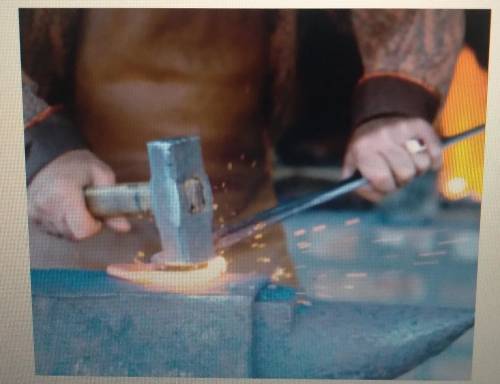 Name the manufacturing process that the worker is using to create the workpiece. The manufacturing